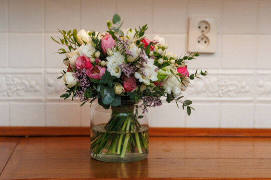 Classic pastel bridal bouquet with roses tulips freesia eustoma hypericum and limonium in glass vase luxury wedding floristry