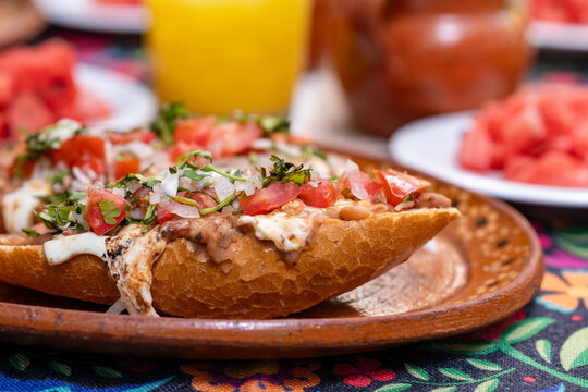 desayuno mexicano, en mesa con mantel, jugos y fruta, juego, frijoles y pan