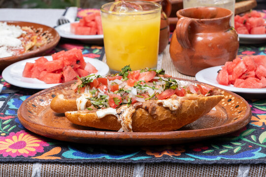 desayuno mexicano, en mesa con mantel, jugos y fruta, juego, frijoles y pan