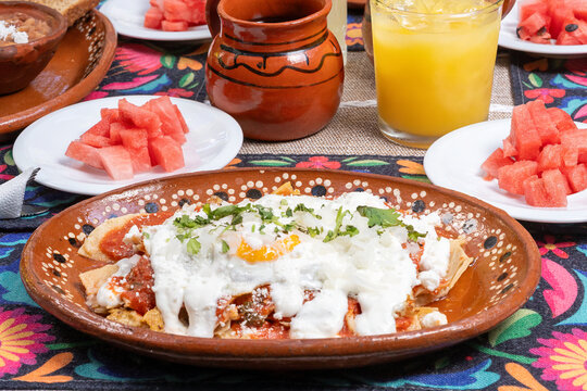 desayuno mexicano, en mesa con mantel, jugos y fruta, juego, frijoles y pan