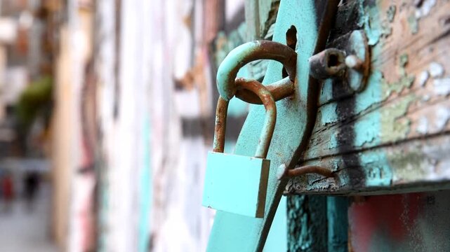 Vintage colorful rusty lock on a weathered metal gate texture