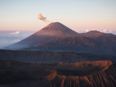 Aerial view of Mount Semeru emitting smoke and the volcanic crater of Mount Bromo at sunrise in Bromo Tengger Semeru National Park Bromo, East Java, Indonesia.
