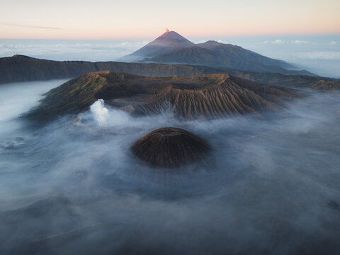 Aerial view of Mount Bromo and Mount Batok surrounded by mist in the Bromo Tengger Semeru National Park, Bromo, East Java, Indonesia.