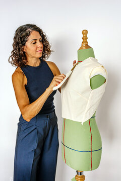 Woman fashion designer working on a pattern with sewing mannequin