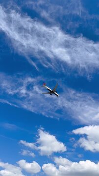 New York, Rockaway Beach, September 2, 2025 - Delta Air Lines airplane flying in cloudy sky above beach coastline