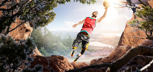 Basketball. A basketball player practices on a basketball court in the wilderness. A beautiful landscape is in the background. © 103tnn