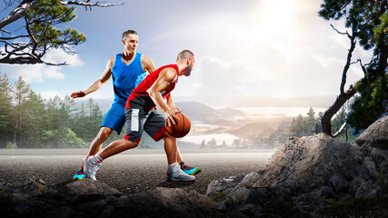 Basketball. Two basketball players practice on a basketball court in the wilderness. A beautiful landscape is in the background. © 103tnn
