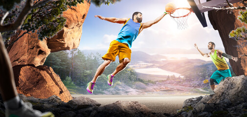 Basketball. Two basketball players practice on a basketball court in the wilderness. A beautiful landscape is in the background. © 103tnn