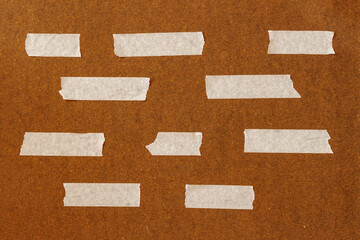 Fototapeta premium Masking tape strips arranged on textured surface, empty space. Natural background for design template, layout, branding usage, surface detail, copy space