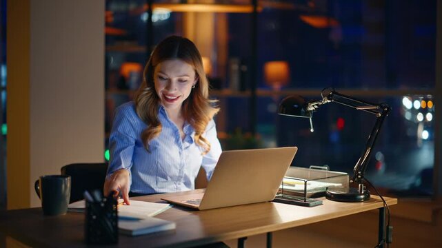 Enthusiastic workaholic typing laptop at night workplace closeup. Smiling woman