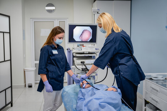 Female patient undergoing endoscopic examination with doctors in clinic, professional gastroscopy bronchoscopy and ENT endoscopy procedure, healthcare and medicine concept