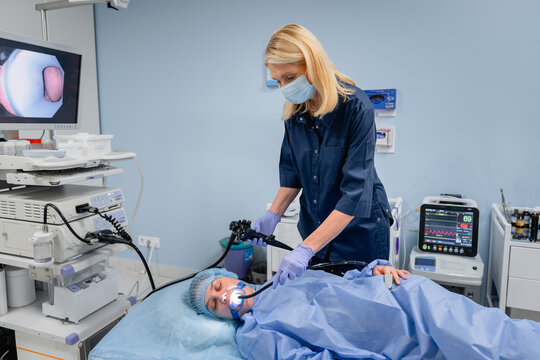 Doctor with woman patient during diagnostic endoscopy in hospital room, gastroscopy bronchoscopy or ENT examination, modern healthcare and medical procedure concept