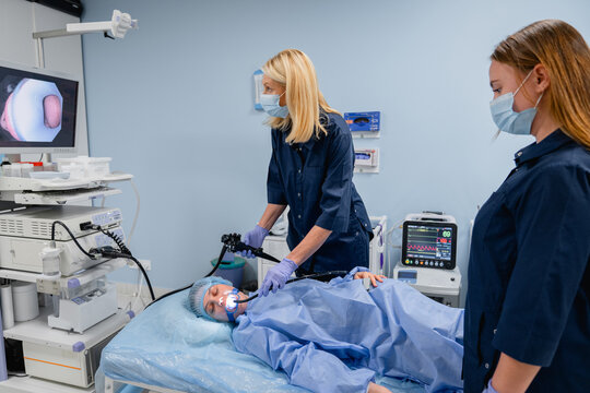 Professional endoscopy procedure with female patient and doctors in clinic, gastroscopy bronchoscopy and ENT diagnostics, hospital service and patient care concept