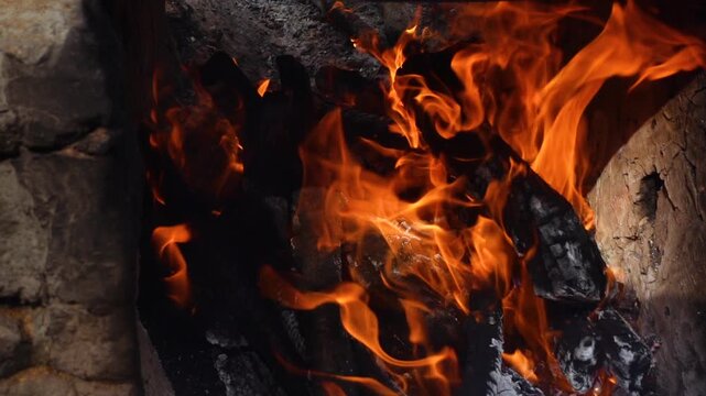 Burning wood boards in the oven close up. Burning firewood and smoke in the handmade oven. Flame in a cozy fireplace at outdoor, keep warm. Hot background.