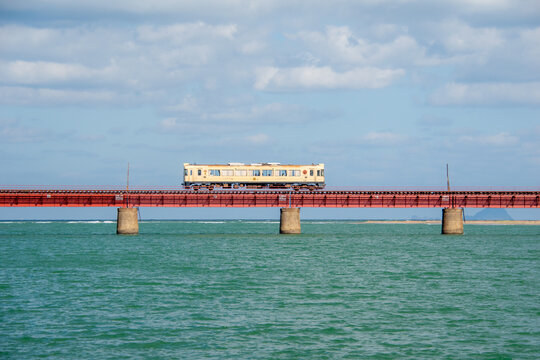 京都丹後鉄道の列車 由良川橋梁を渡る赤い車両と青い空(Red train of Kyoto Tango Railway crossing the Yuragawa Bridge under blue sky)