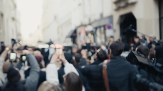 Unfocused crowd of journalists and photographers filming an event
