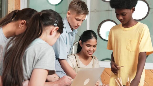 Caucasian teacher giving comment or advise student while smart bot pointing at laptop screen at classroom. Diverse student taking a note while teacher teach lesson while using computer. Edification