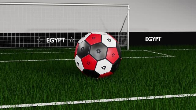 Spinning red black white soccer ball descending on pitch, bouncing then resting before net EGYPT