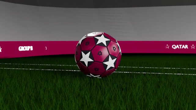 Pullback showing rotating maroon starred soccer ball falling onto turf, settling by QATAR ribbon