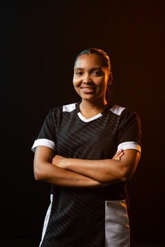 African American woman posing crossing arms studio black jersey white-trim warm rim right cool left