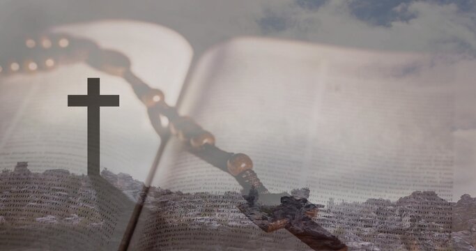 Displaying open religious book with wooden rosary and crucifix lying on surface, rocky ridge cross