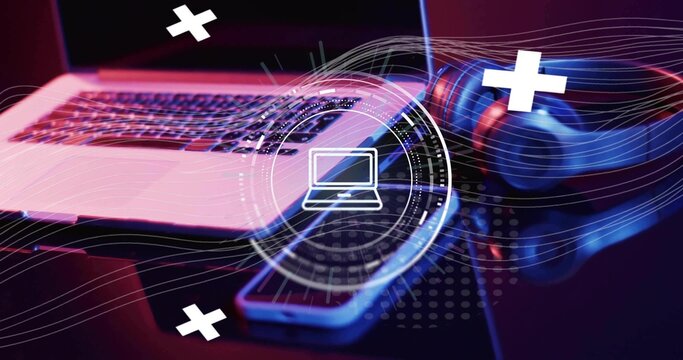 Showing silver laptop, phone and over-ear headphones on desk under magenta blue gels HUD overlays