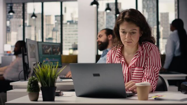 Startup employee using laptop to solve daily management tasks in office environment, productivity and company development in modern enterprise smart office. Businesswoman on the job.
