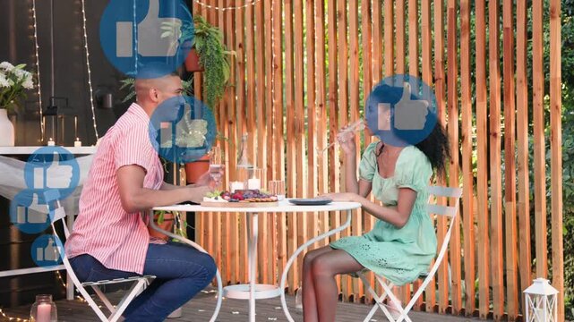 Man clinking glasses with woman, sipping chatting on deck, floating likes boosting marketing buzz