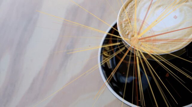 Overlay starting at small orange point, sweeping gold rays over cup foam, highlighting swirl