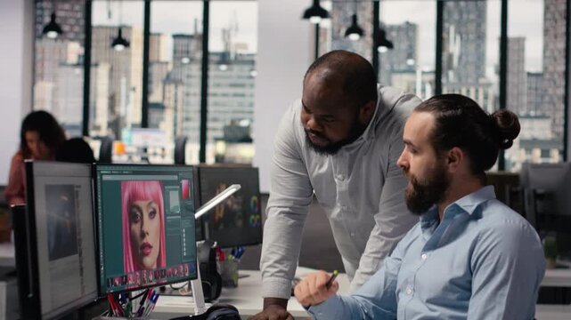 Diverse team of photo editing and color grading on retouching software, graphic design editorial materials. Image selection on computer monitor preparing catalog results in post production.