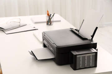 Fototapeta premium Modern printer on desk near light curtain in office