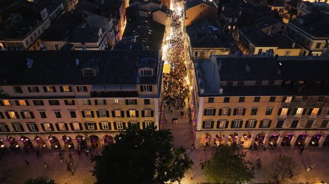 Aerial top down view of the famous Liston street in Corfu island Greece at night with illuminated arches glowing windows and crowds of tourists walking in the historic old town center