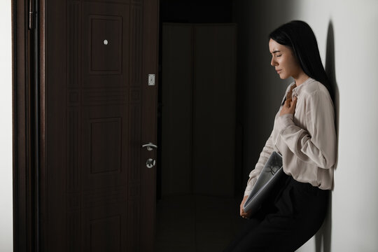 Young businesswoman with folder having panic attack in hallway at office