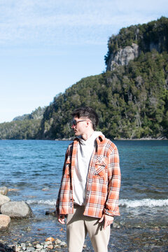 Chico modelo con camisa a cuadros en monta&ntilde;as y lago de la Patagonia Argentina
