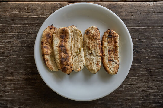 grilled bananas on white plate over wood