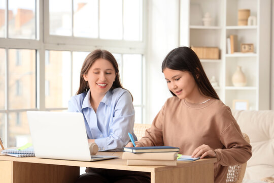 Teenage girl studying with tutor at home