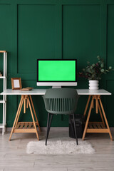 Fototapeta premium Modern workplace with computer near green wall in room