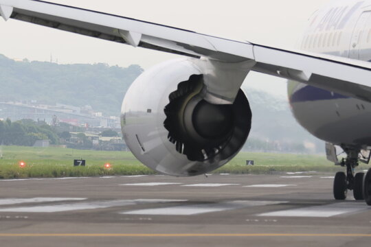 Commercial airplane jet engine and wing on the airport runway.
