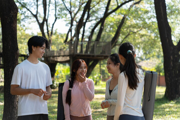 Naklejka premium Group of yoga class talking together at public class