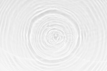 Fototapeta premium White water with ripples on the surface. Defocus blurred transparent white colored clear calm water surface texture with splashes and bubbles. Water waves with shining pattern texture background.