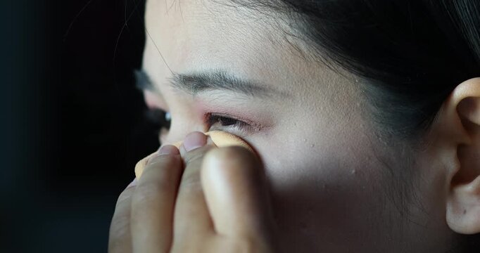 Woman applying foundation under the eye with a makeup sponge, Beauty routine and cosmetic application, Working age asian woman, Close-up
