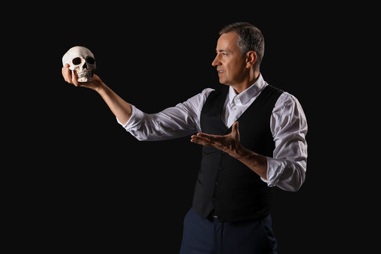 Mature actor with skull on dark background