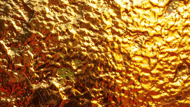 Abstract background of a textured rough gold metallic sheet surface showing weathered golden foil with industrial shimmer and luxury grainy patterns for creative design wallpaper.