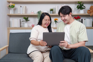 Fototapeta premium Asian couple using laptop together for online work or study at home