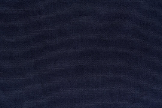 Navy blue fabric texture background, blend of rayon, linen, and cotton fibers. Close-up of woven textile material with natural slub pattern.
