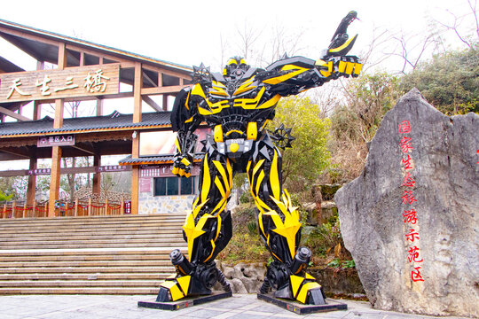 Chongqing, China, January 23, 2026: Giant yellow transformer robot statue standing at entrance Wulong Karst National Park (Three Heavenly Bridges) of tourist attraction. Inspired by fiction and movie 
