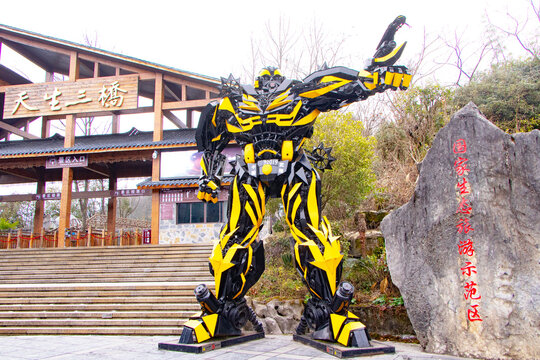 Chongqing, China, January 23, 2026: Giant yellow transformer robot statue standing at entrance Wulong Karst National Park of tourist attraction. Inspired by fiction and movie. Three Heavenly Bridges.