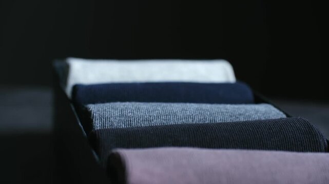 New collection of colorful men cotton socks neatly rolled and arranged in black gift box, showcasing soft, organized assortment ideal for everyday comfort or gifting. Close up of rolled socks in a box