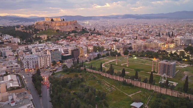 Aerial perspective of athens, greece, featuring the illuminated acropolis with the parthenon and the ancient ruins of the temple of olympian zeus against a beautiful twilight cityscape