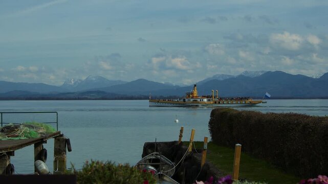 Historic paddle steamer Ludwig Fessler on Chiemsee lake with the Chiemgau Alps in the background.